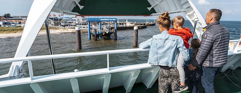 Eine Familie, auf dem Freideck, während das Schiff anlegt.