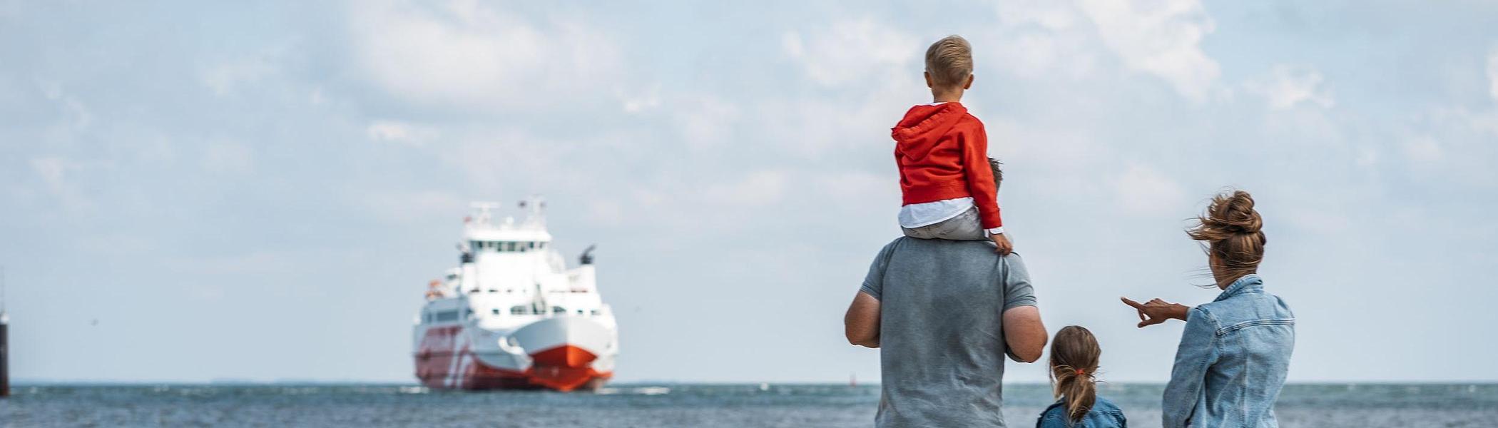 Familie med hund på stranden og ser Römöexpress