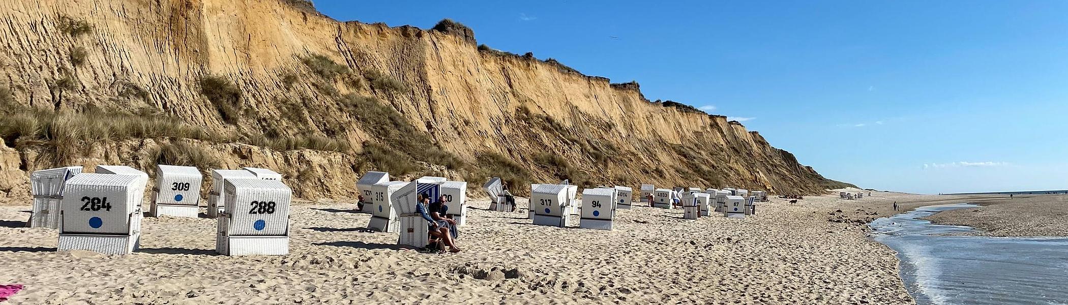 The beach under the cliff, with beach chairs.