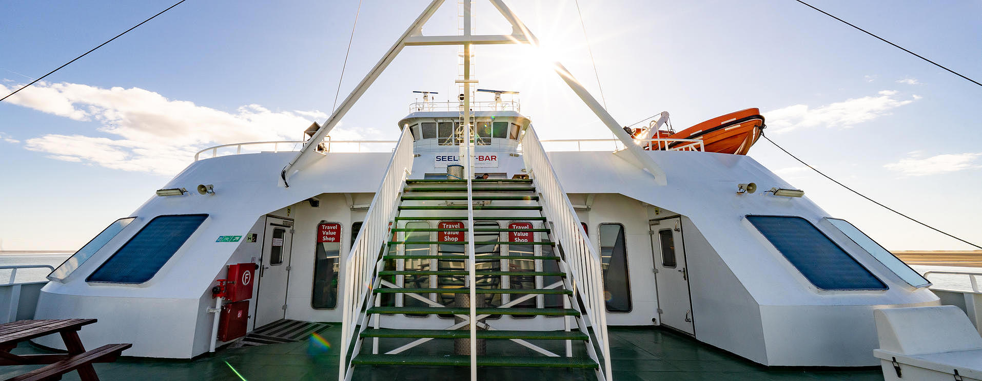 The outer deck of the FRS Sylt ferry in bright sunshine, including the staircase. 