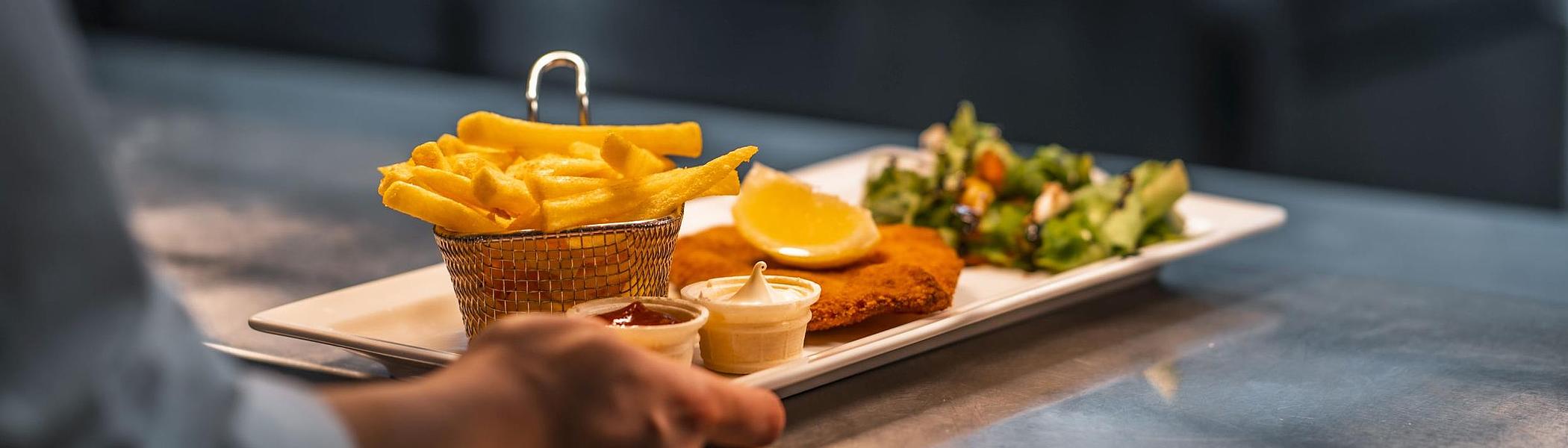 Schnitzel og pommes frites fra restauranten om bord.