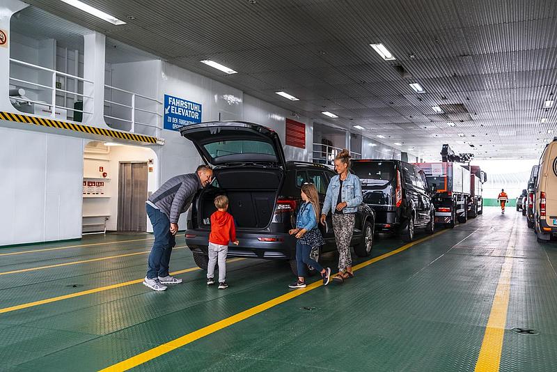 Eine Familie steigt aus dem Auto, auf dem Autodeck.