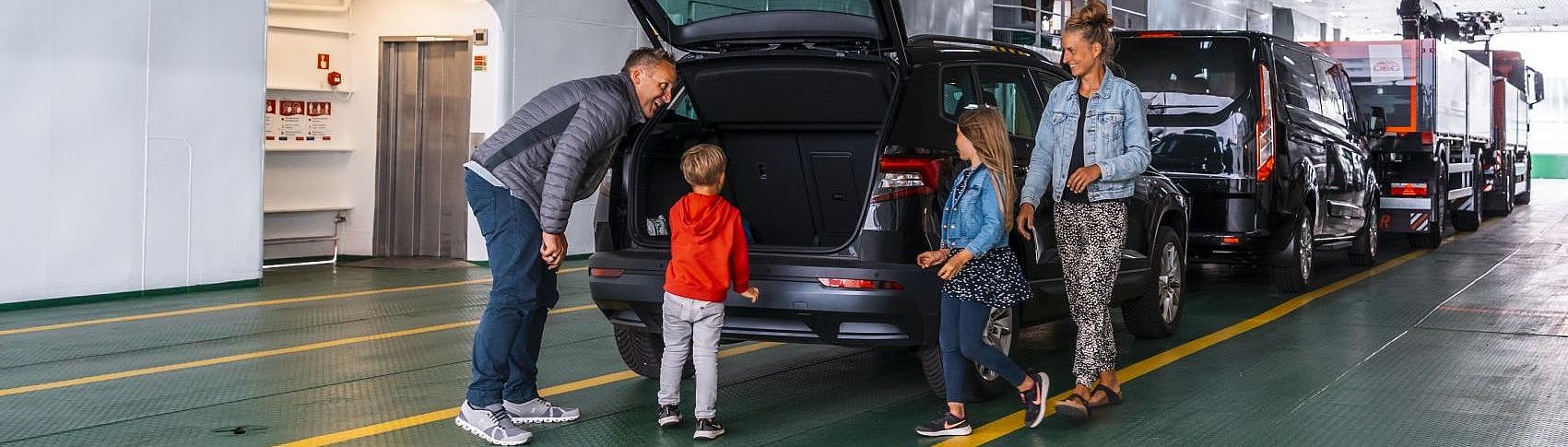 Eine Familie steigt aus dem Auto, auf dem Autodeck.